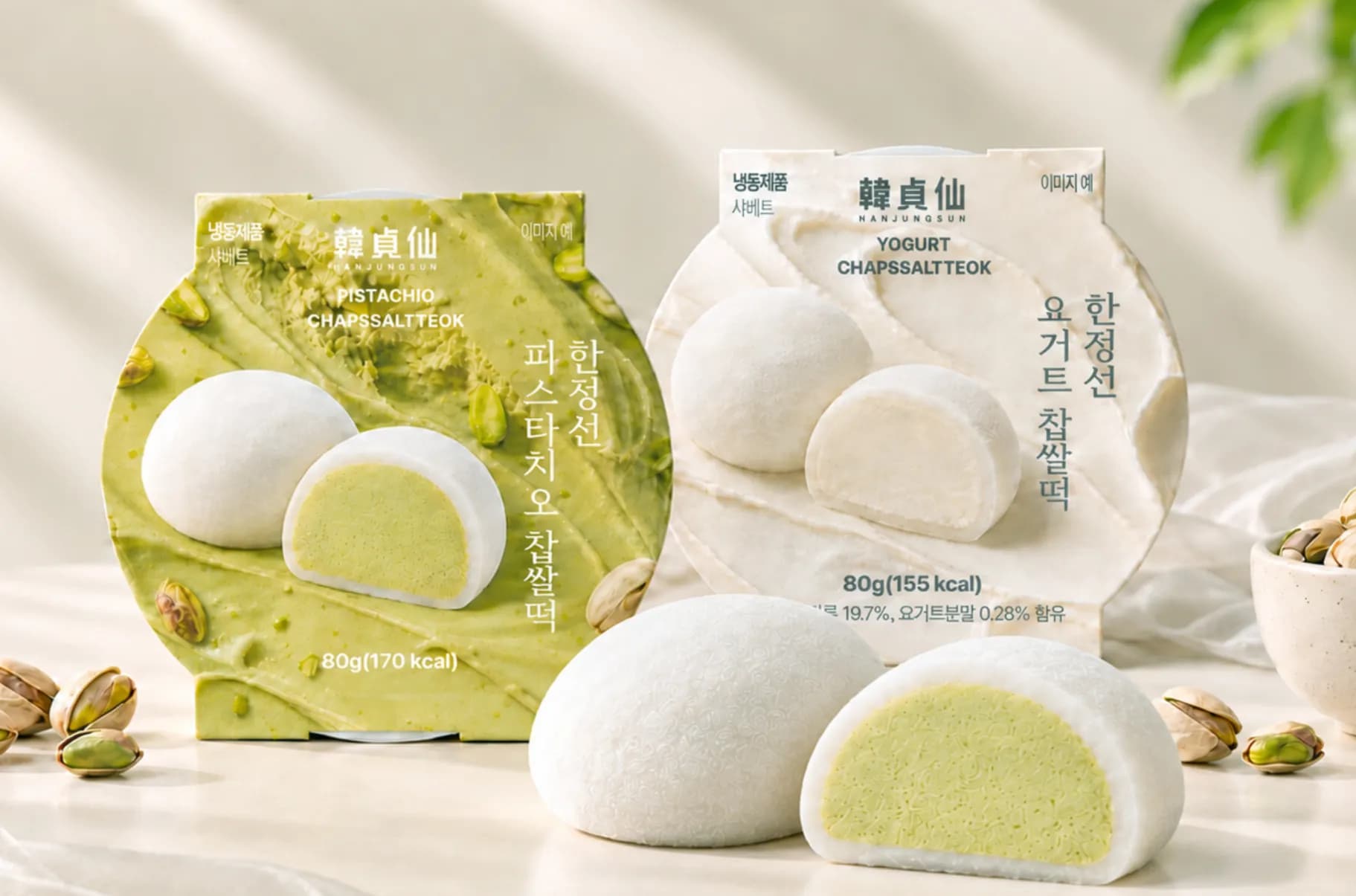韓國便利商店GS25與聖水洞「韓貞仙」聯名推出的冷藏麻糬,展示開心果風味(左)與優格風味(右)圓形包裝盒及飽滿奶油剖面。