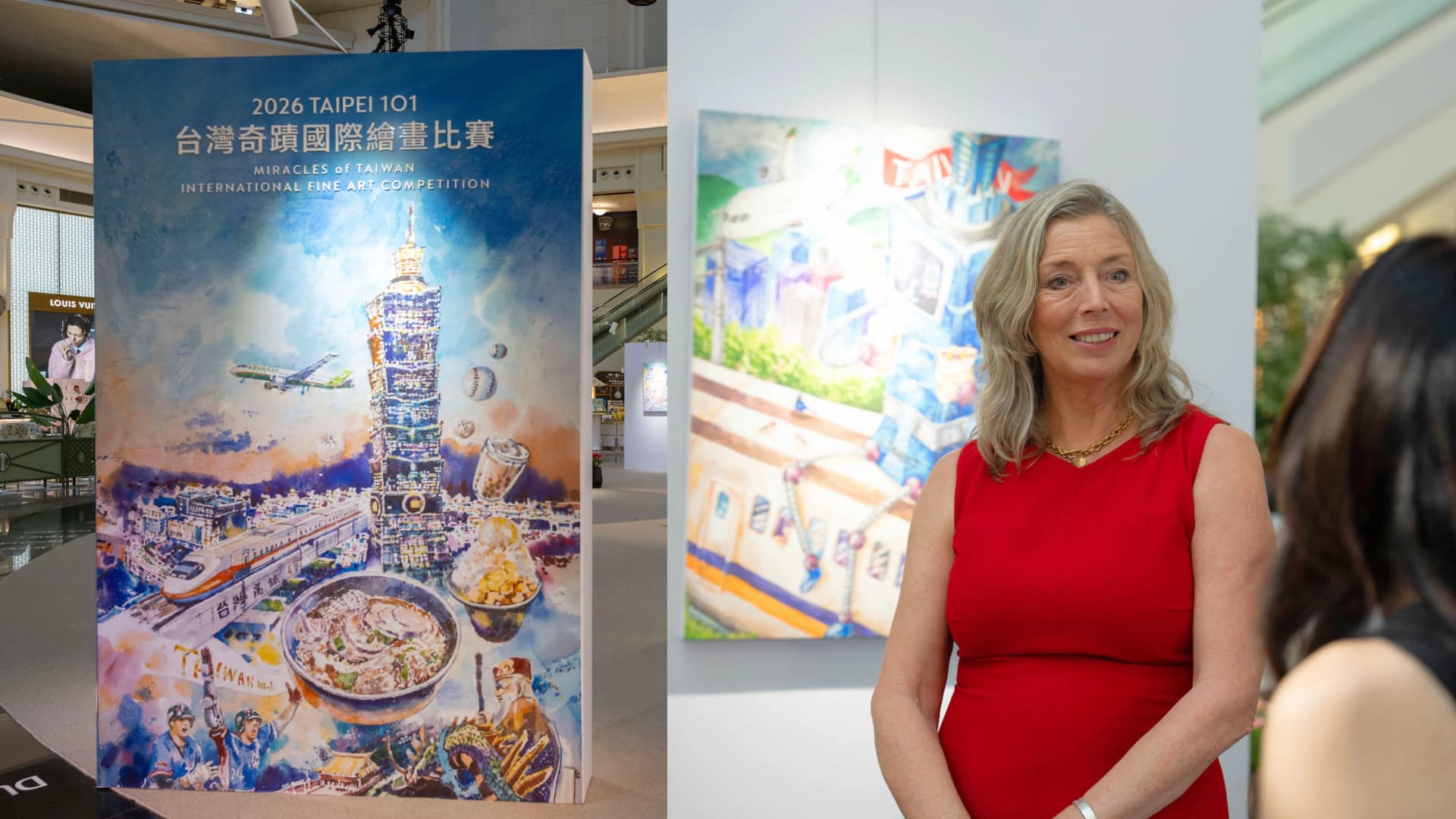 英國插畫家Julia Gash現身台北101「2026台灣奇蹟國際繪畫比賽」展區,後方可見得獎作品。