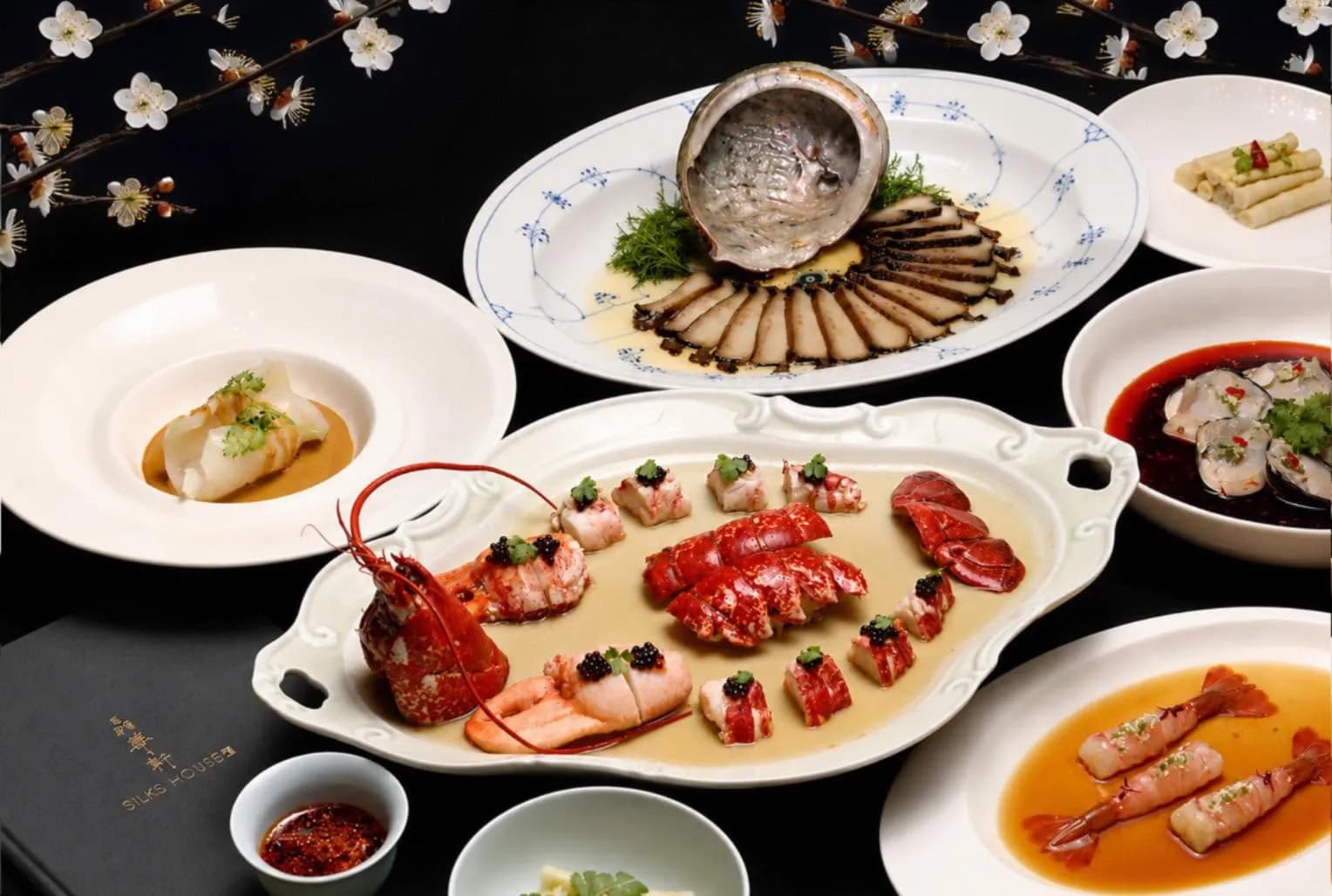 晶華軒多道粵菜料理擺盤,包括龍蝦、鮑魚、蝦料理與海鮮菜色,桌面可見「晶華軒 SILKS HOUSE」字樣。