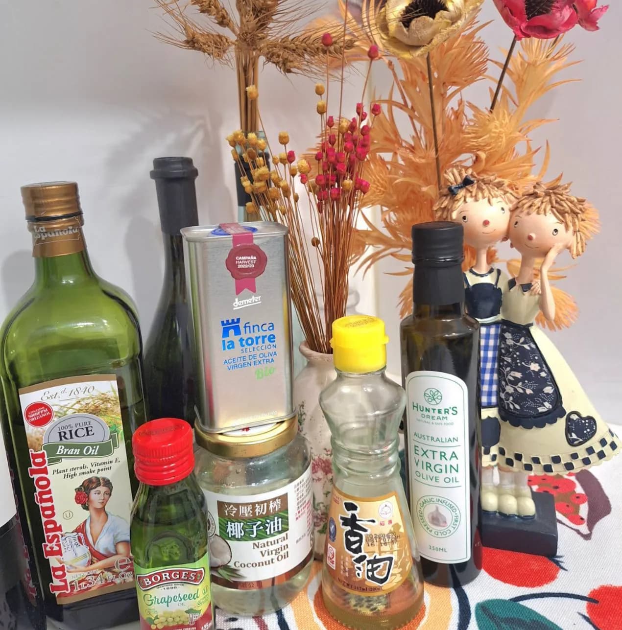 桌面擺放多款食用油,包括香油、椰子油、米糠油、橄欖油、葡萄籽油與蒜味調和油。