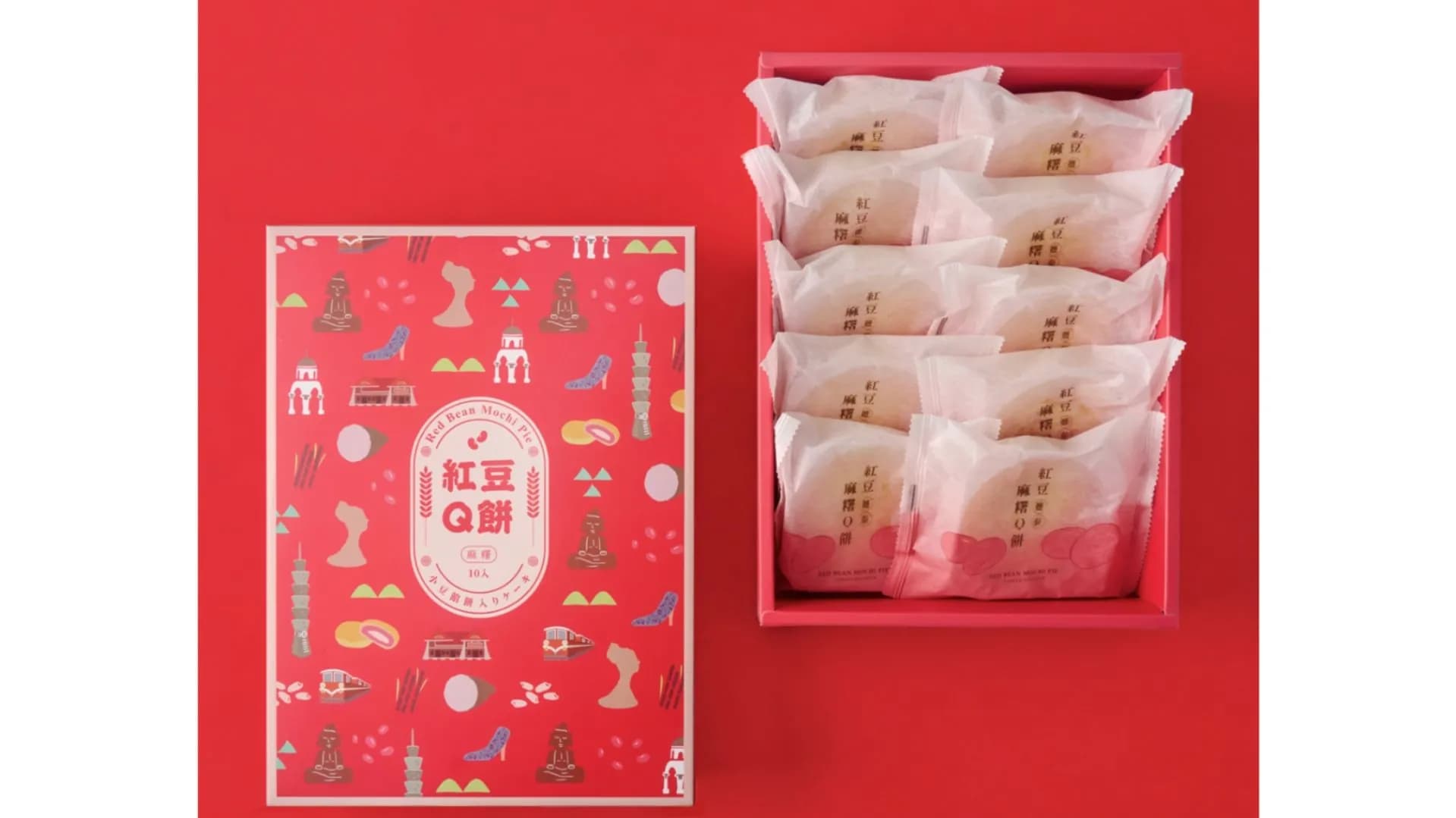 紅色背景上的躉泰「紅豆麻糬Q餅」10入禮盒,左側外盒印有台北101與女王頭等台灣地標插畫,右側平放著裝滿獨立包裝紅豆麻糬Q餅的禮盒內盤。